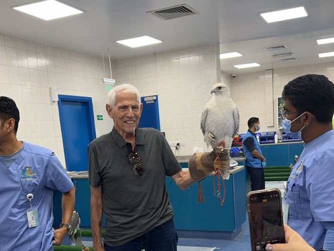 Rachel Friem's father smiling while holding a white falcon during a family trip to the United Arab Emirates.
