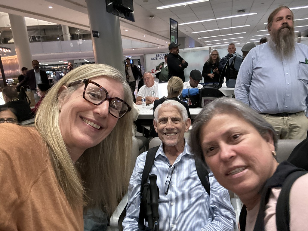 Rachel Friem taking a selfie with her father and his wife at the airport before a family trip.