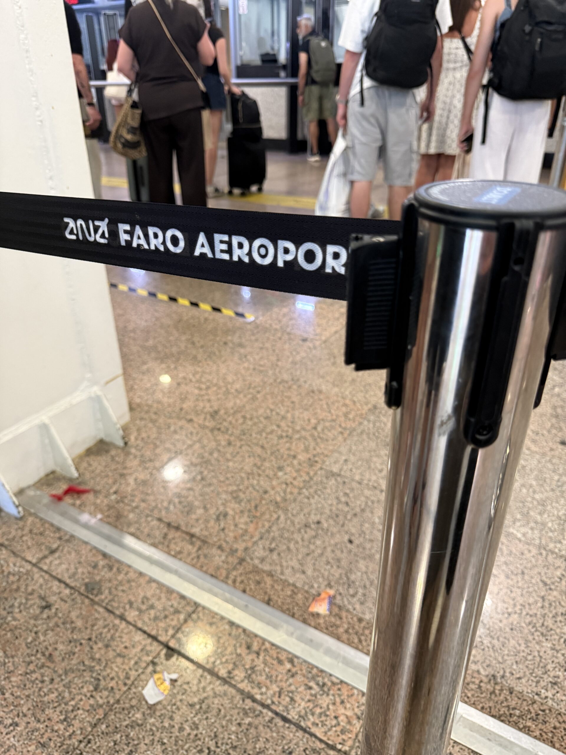 Travelers waiting in the passport-control line at Faro Airport